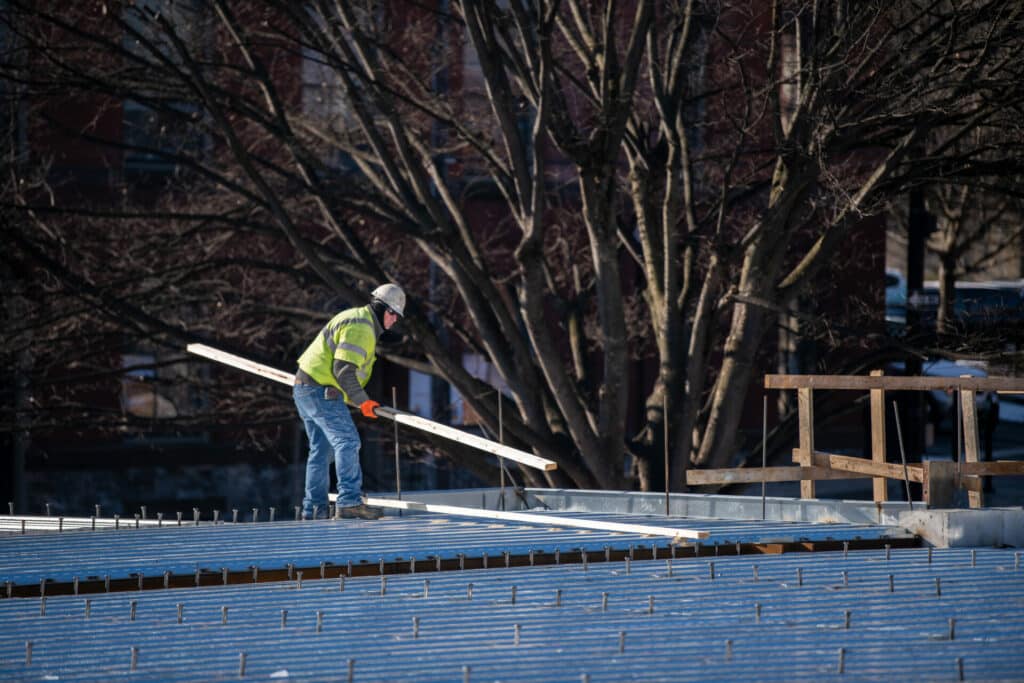 construction worker laying a piece of lumber