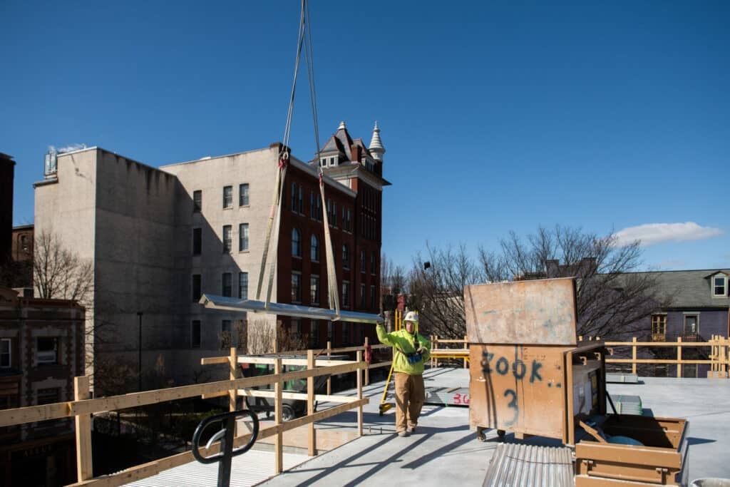 beam lifting onto rooftop from a crane