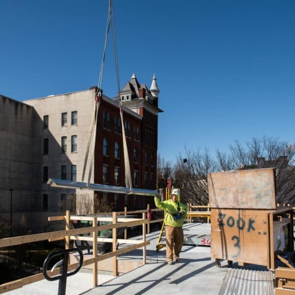 beam lifting onto rooftop from a crane