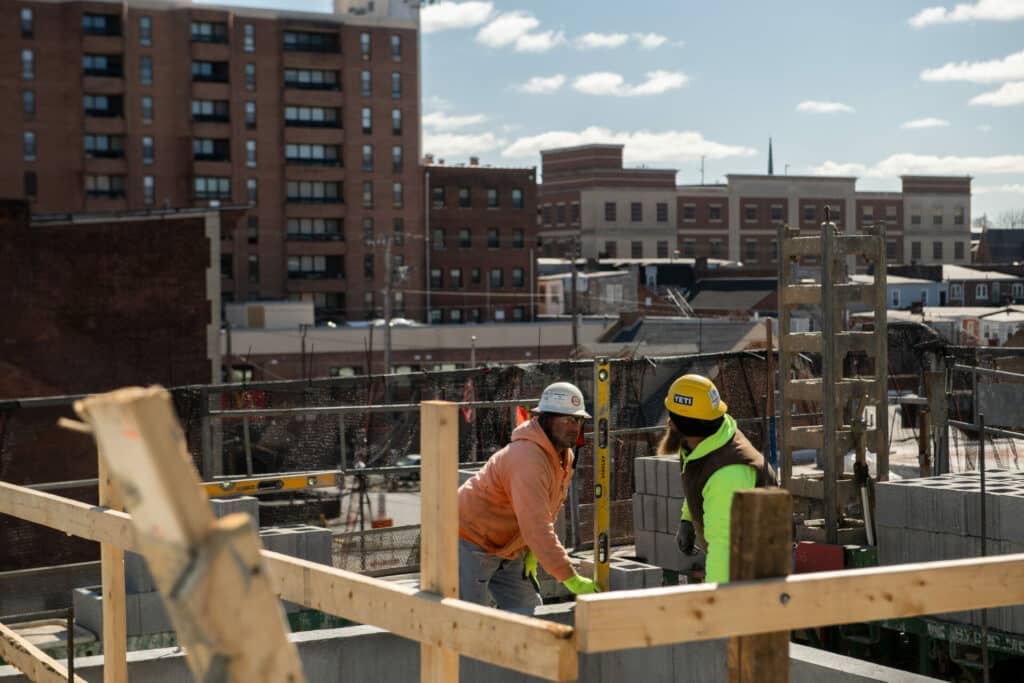 two construction workers using a level tool