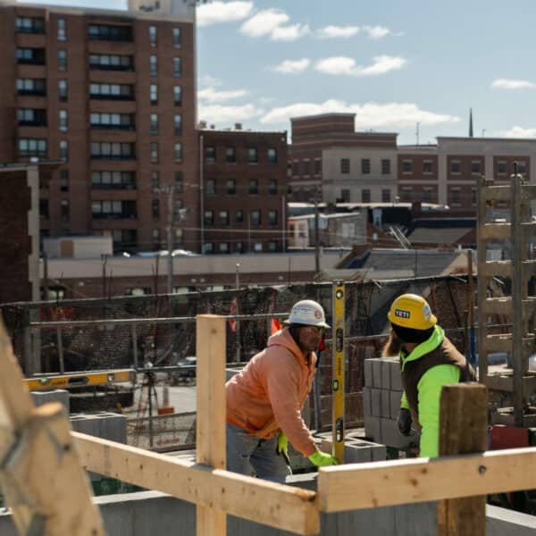 two construction workers using a level tool