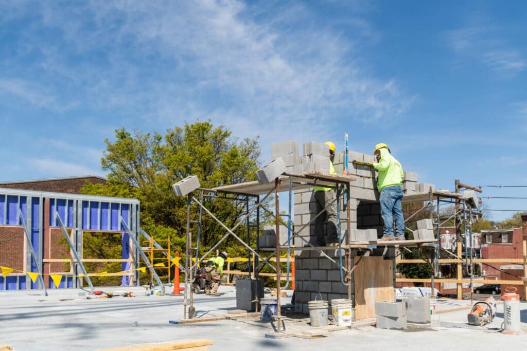 two workers laying cement block