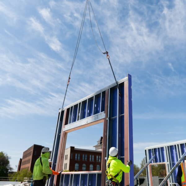 crane putting wall onto construction site