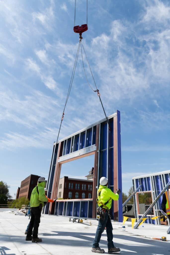 crane putting wall onto construction site